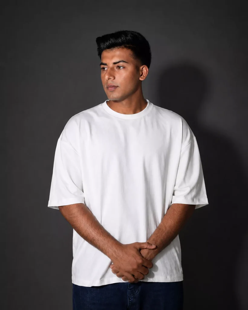 White oversized box fit t-shirt with drop shoulder styled in studio lighting